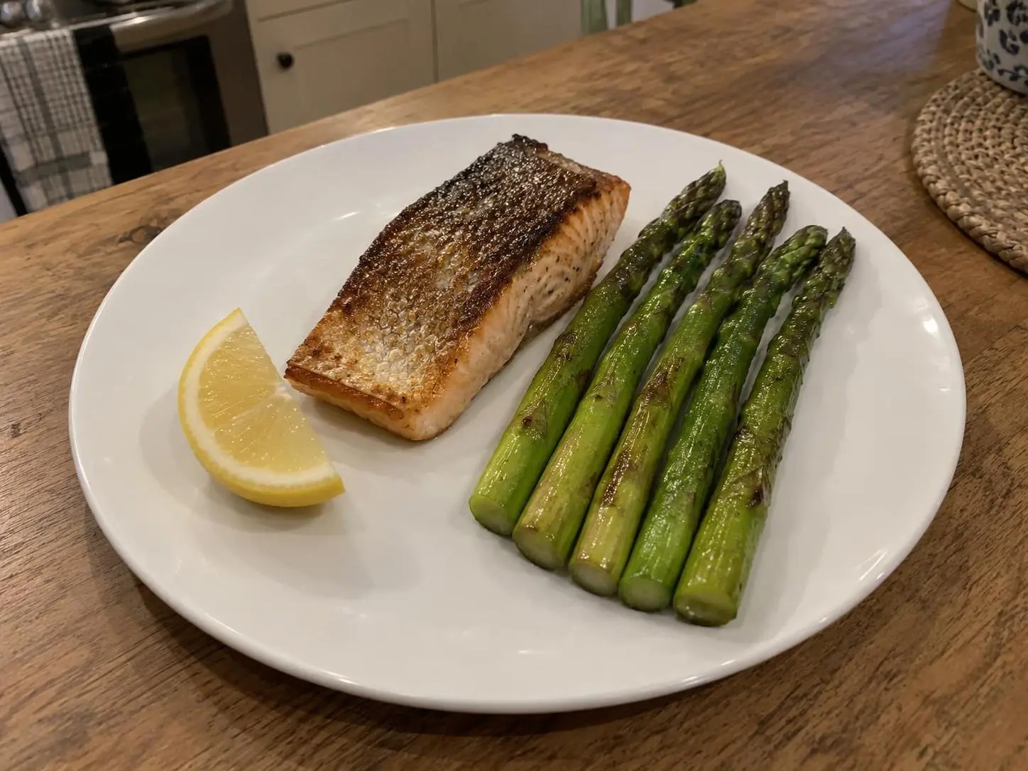 AI-made sample phone photo of a seared salmon fillet with five asparagus spears and a lemon wedge; generated demonstration, not a real customer dish.
